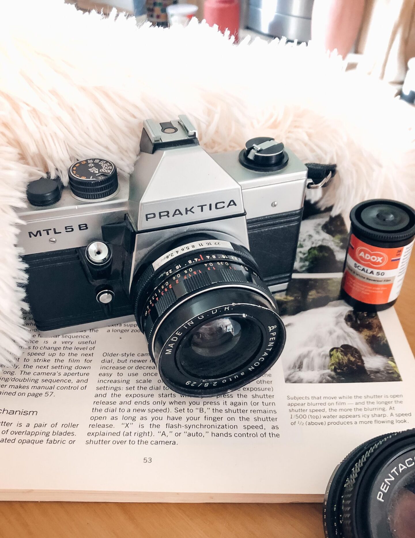 Praktica film camera next to roll of film